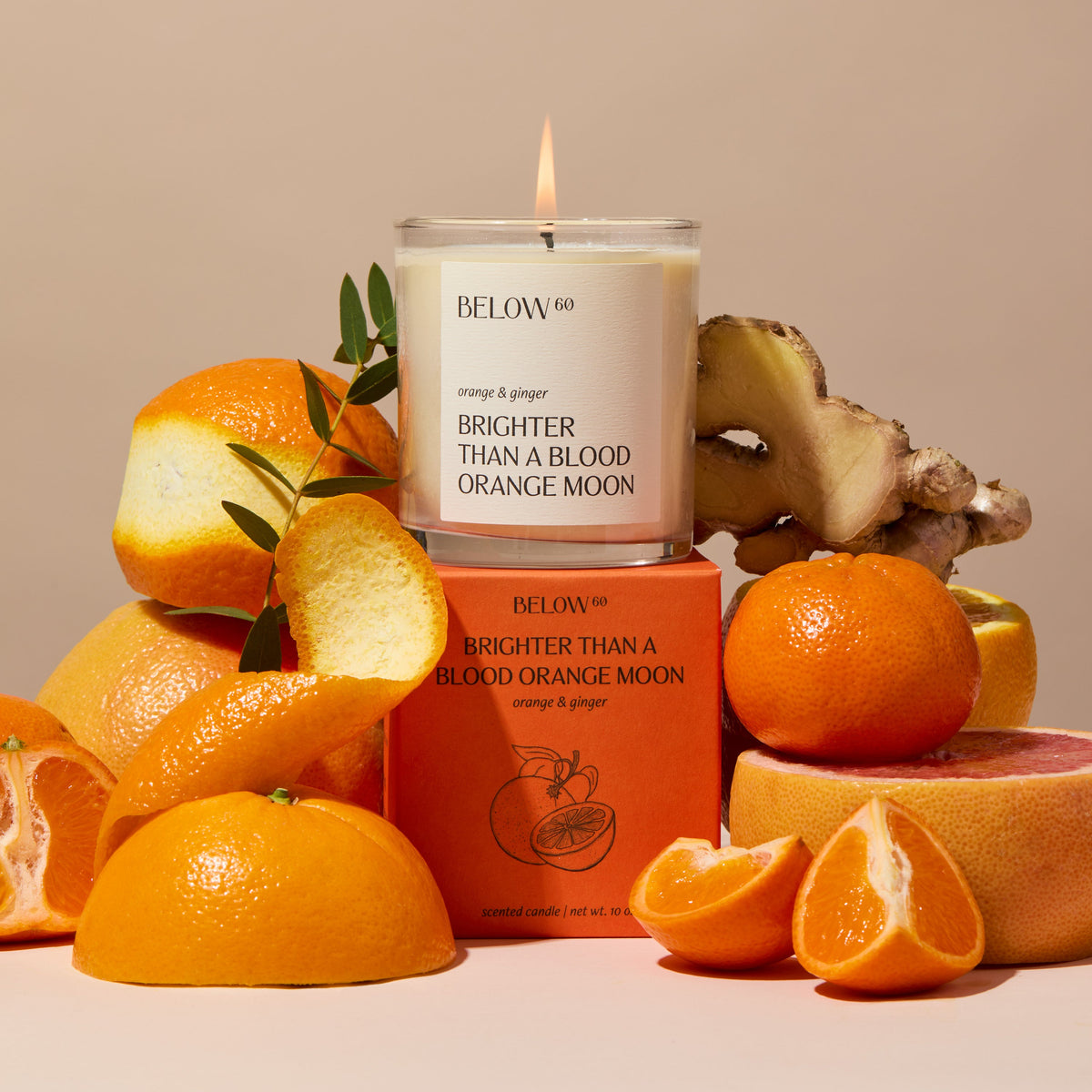 Blood orange candle surrounded by oranges